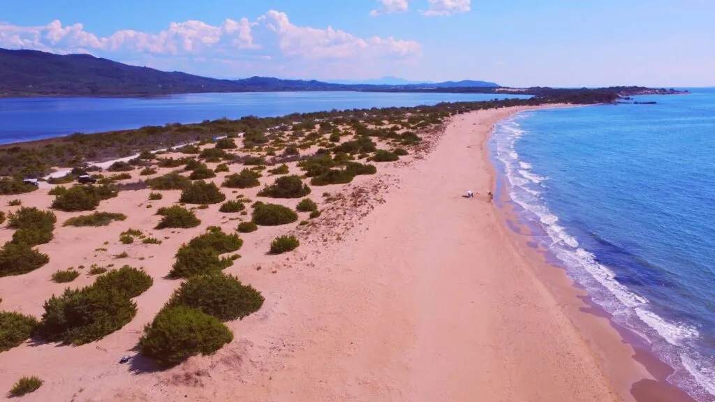 Halikounas beach. The main photo on the Chill Out Chalikounas Villas website depicts a serene and picturesque view of a beach, showcasing crystal-clear turquoise waters and a pristine sandy shoreline, flanked by lush greenery. This idyllic scene captures the tranquil and beautiful natural environment surrounding the villas, inviting viewers to imagine a peaceful and relaxing getaway in this stunning location.